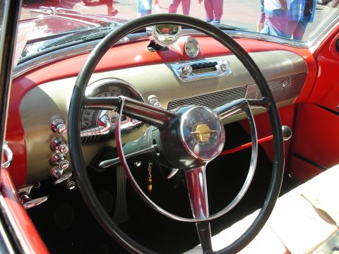 1998 Ford Crown Victoria - The interior of a vintage automobile features a prominent steering wheel and a dashboard with chrome details.