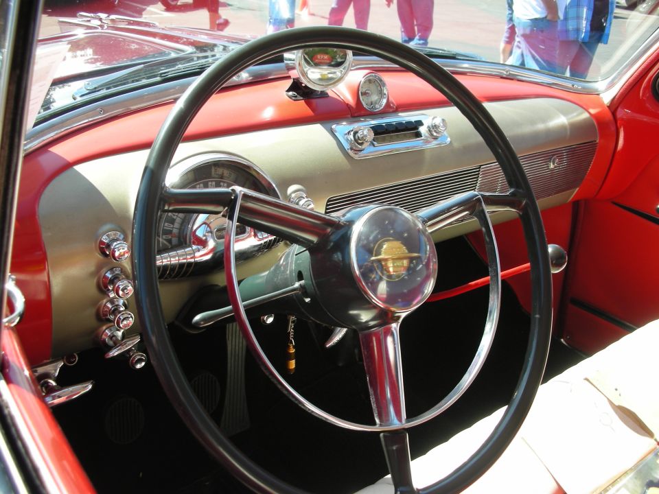 Classic car interior with a large steering wheel and chrome accents