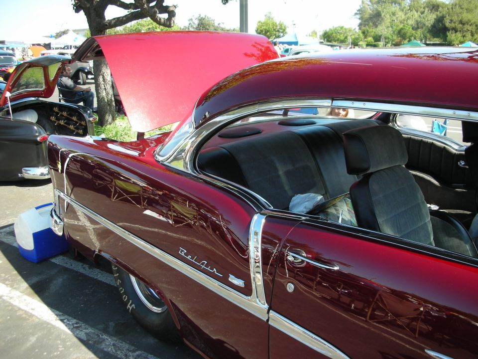 Maroon 1956 Chevrolet Bel Air coupe with hood open, side view, showing interior and chrome trim