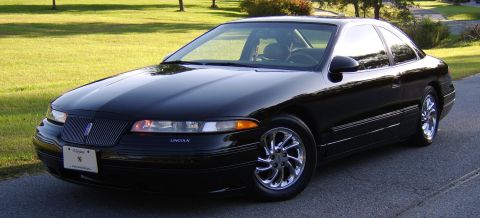 1996 Mercury Grand Marquis - A shiny black Lincoln coupe sits on a paved surface, with a grassy area and trees behind it.