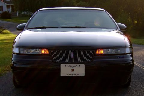 1996 Mercury Grand Marquis - This black Lincoln Town Car is viewed from the front, displaying its grille and headlights.