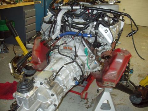 2007 Ford Mustang - Engine and transmission assembly, likely from a 2007 Ford Mustang, is mounted on shop stands.
