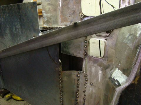 1948 Jeep Wrangler - Metal body panels are being worked on, with visible rivets and seams indicating repair work.