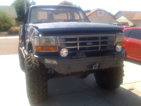 1994 Ford Bronco - This Ford F-Series truck features a custom bumper and off-road tires, with a NASCAR sticker on the front.