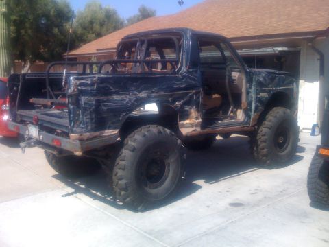 1994 Ford Bronco - This heavily modified SUV is missing doors and has extensive body damage, suggesting it's a project vehicle.