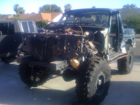 1994 Ford Bronco - This heavily modified 1994 Ford Bronco shows significant damage and custom off-road tires.