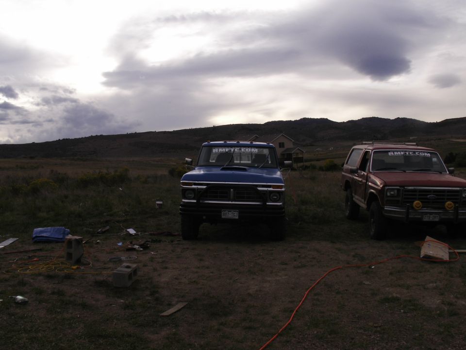 Blue 1970s pickup truck front view with red pickup truck to the right