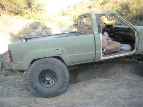 1985 Toyota 4Runner - This modified pickup truck is navigating a challenging rocky path off-road.