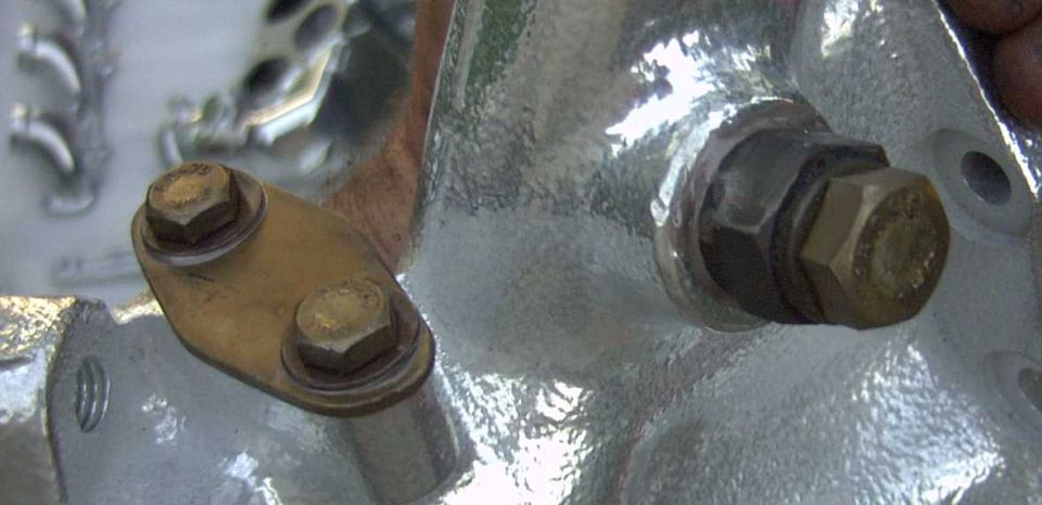 Silver manifold with yellow two-bolt block-off plate and separate large hex bolt