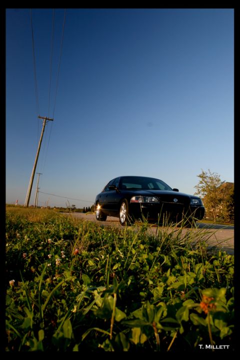 2003 Mercury Marauder - A black 2003 Mercury Marauder is parked on the side of a road under a clear blue sky.