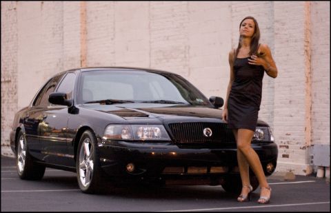 2003 Mercury Marauder - A black 2003 Mercury Marauder is shown with a woman posing next to it in front of a brick wall.