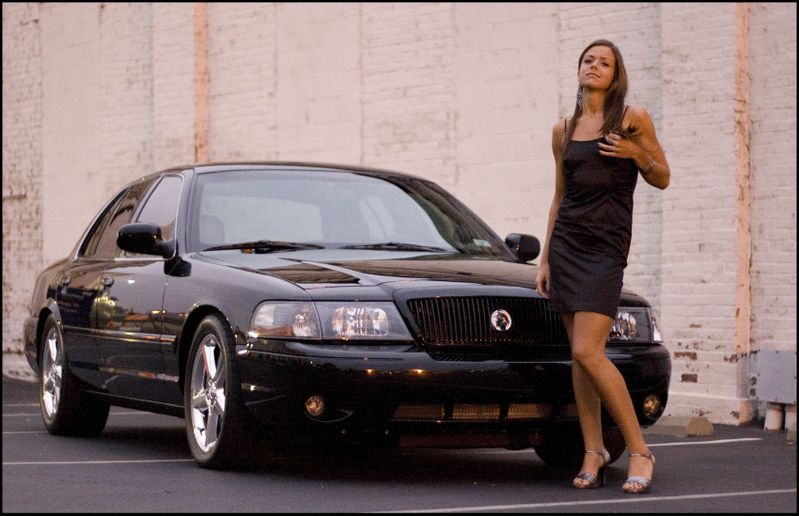 Black 2003 Mercury Marauder with a woman standing beside it