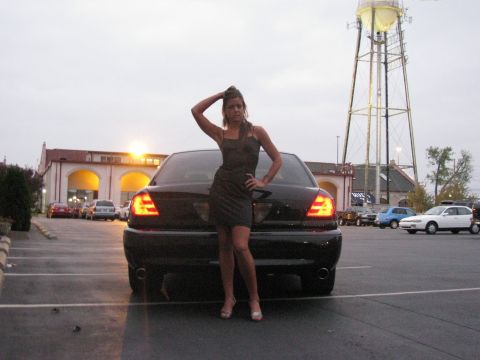 2003 Mercury Marauder - Woman poses by a black 2003 Mercury Marauder in a parking lot with a water tower in the background.