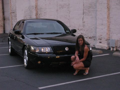 2003 Mercury Marauder - A woman poses in front of a black 2003 Mercury Marauder parked in a lot.