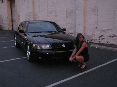 2003 Mercury Marauder - A black 2003 Mercury Marauder is shown from the front with a woman crouching beside it.