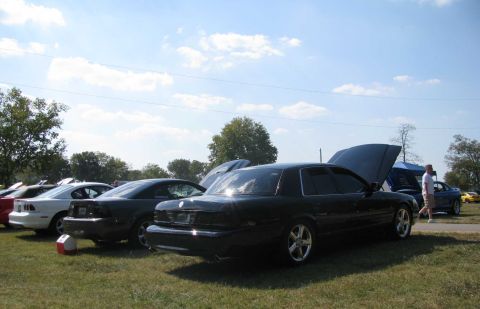 2003 Mercury Marauder - A black 2003 Mercury Marauder is parked at an outdoor event with its hood open, alongside other vehicles.