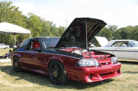 2003 Mercury Marauder - A red and black 1993 Ford Mustang coupe is displayed with its hood open, revealing the engine and racing seats.