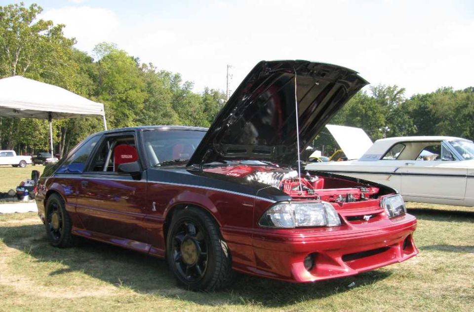 Red and black 1993 Mustang coupe with hood open, racing seats visible