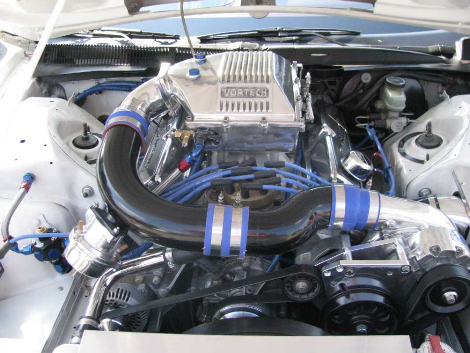 Engine bay with a Vortech supercharger and chrome intake piping
