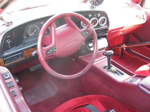 2003 Mercury Marauder - The interior of a car shows a red dashboard, steering wheel, and seats, with additional gauges and a roll cage visible.