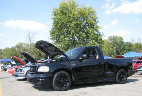 2003 Mercury Marauder - Black Ford F-150 SVT Lightning pickup truck shown with its hood open at an outdoor car event.