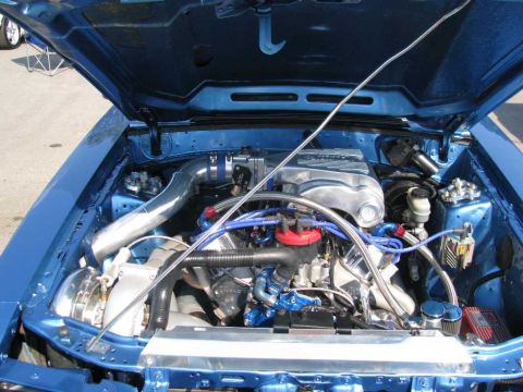 2003 Mercury Marauder - The engine bay of a blue car is shown with the hood open, revealing the engine and various components.