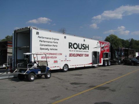 2003 Mercury Marauder - A ROUSH trailer is parked with a golf cart in front and a black car in the background.