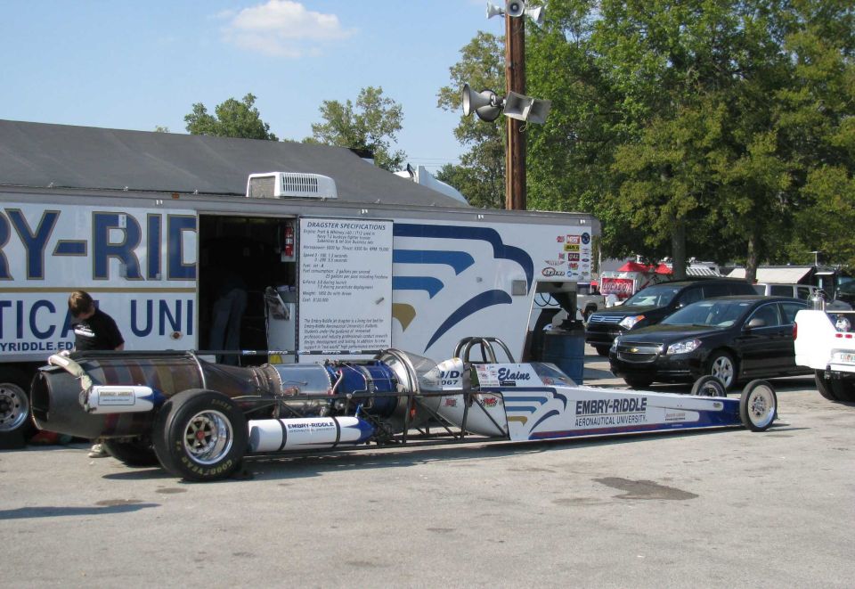 Jet dragster with Embry-Riddle livery parked next to a trailer