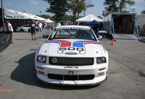 2003 Mercury Marauder - A white Ford Mustang race car, number 500, is parked at a track event with tents and a trailer in the background.