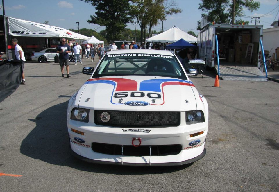 Front view of a white Ford Mustang race car with "Mustang Challenge" on windshield and "500" on hood