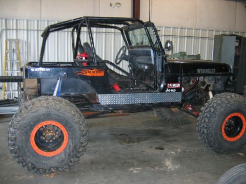 1992 Ford Mustang - This heavily modified Jeep Wrangler features oversized tires and a custom roll cage, indicating it's built for off-road use.