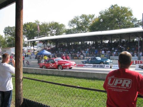2003 Mercury Marauder - A drag race is underway with two cars on the track and spectators in the stands.