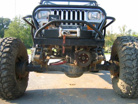 1992 Ford Mustang - Front view of a heavily modified Jeep Wrangler a winch, custom bumper, and oversized off-road tires.