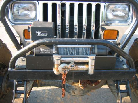 1992 Ford Mustang - A close-up of a Jeep Wrangler's front end shows a winch and a chrome grille, indicating a model from the early 1990s.