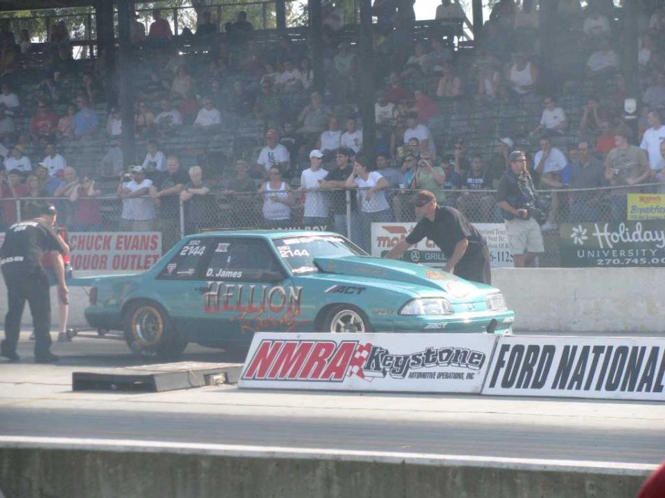 Teal drag car with "HELLION" text on track