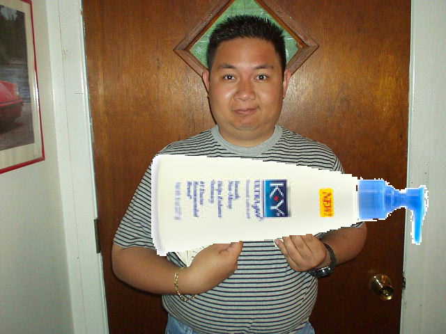 Man holding a large bottle of KY Jelly lubricant with a blue applicator nozzle