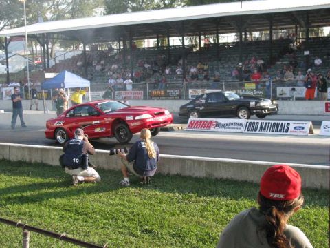 2003 Mercury Marauder - Two vehicles compete in a drag race, with photographers positioned trackside to capture the action.