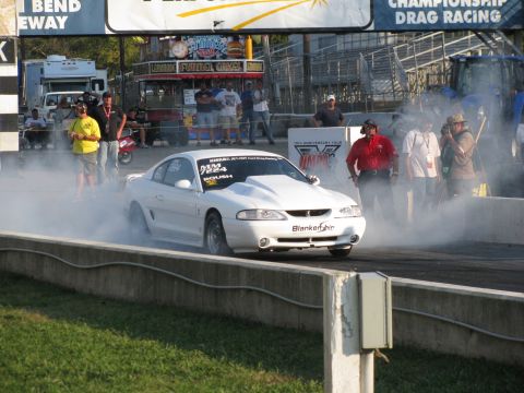 2003 Mercury Marauder - White Ford Mustang Cobra performs a burnout at a drag racing event.