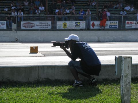 2003 Mercury Marauder - A photographer captures the action at a drag racing event, with spectators in the background bleachers.