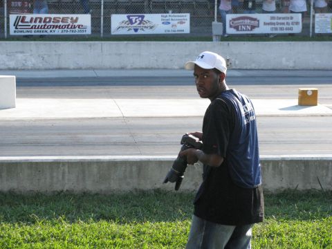 2003 Mercury Marauder - A photographer stands on the grass at a drag strip, holding a camera and looking back.