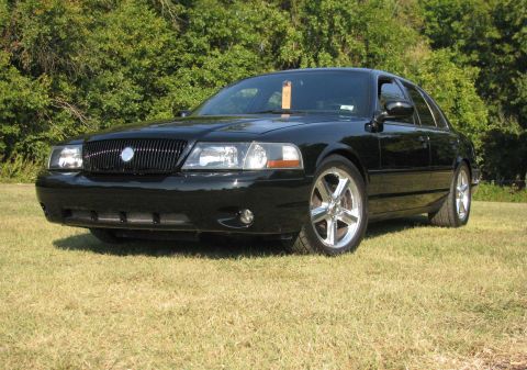 2003 Mercury Marauder - A black 2003 Mercury Marauder is parked on a grassy area with trees in the background.