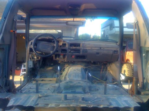 1994 Ford Bronco - The interior of a disassembled SUV, likely from the early to mid-1990s, is shown with its components removed.