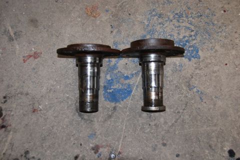 1996 Ford Bronco - Two metal hubs with bolt holes are shown on a concrete surface.