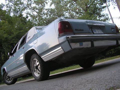1988 Ford Crown Victoria LTD - Rear view of a light blue 1988 Ford Crown Victoria LTD sedan with a white vinyl roof.