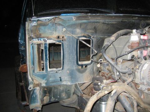 1994 Ford Bronco - The front end of a vehicle is disassembled, showing the firewall and engine bay components.