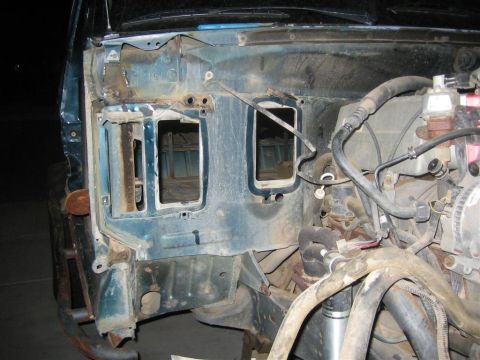 1994 Ford Bronco - The firewall of a teal vehicle is shown with engine components and cutouts for access.