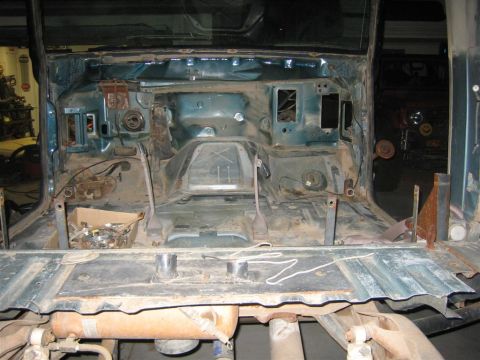 1994 Ford Bronco - The interior of a vehicle has been stripped down to its bare metal frame, revealing exposed components and wiring.