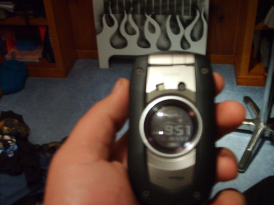 Cell phone with digital display showing .951, held in hand