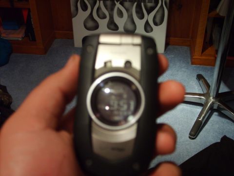 1995 Ford Bronco - A hand holds a flip phone displaying the time '9:51' with a flame graphic in the background.