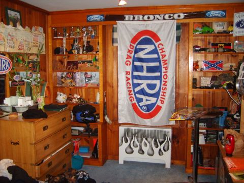 1995 Ford Bronco - A room decorated with Ford and Bronco memorabilia, trophies, and an NHRA flag.